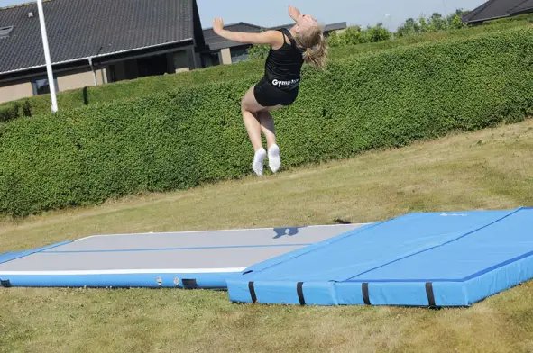 Familie der bruger airtrack til sjov træning i haven